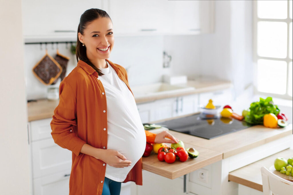Pregnant woman choosing fresh vegetables at home